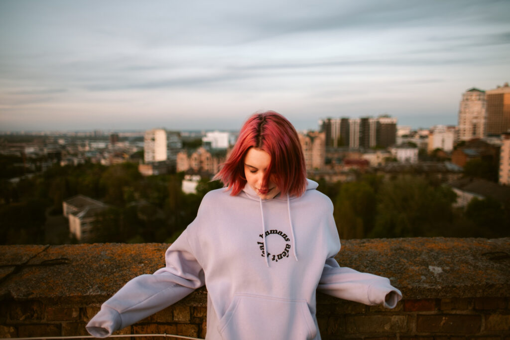 Portrait of peaceful young woman standing on the rooftop of building in the city