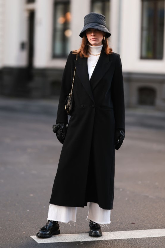 COLOGNE, GERMANY - DECEMBER 07: Karla Jenders wearing Fendi mini baguette bag, Isabel Marant black loafer, Zara white jeans, Ivy & Oak black coat, Arket black bucket hat, H&M beige turtleneck and Prada gloves on December 07, 2021 in Cologne, Germany. (Photo by Jeremy Moeller/Getty Images)