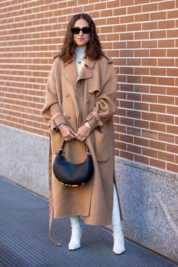 MILAN, ITALY - FEBRUARY 23: Erika Boldrin seen wearing brown coat, white dress, overknees boots, black bag outside of Fendi fashion show during the Milan Fashion Week Fall/Winter 2022/2023 on February 23, 2022 in Milan, Italy. (Photo by Christian Vierig/Getty Images)