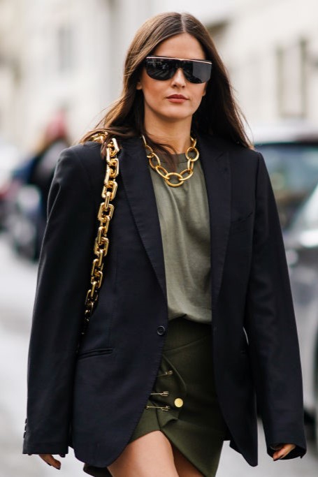 PARIS, FRANCE - FEBRUARY 29: Paola Alberdi wears sunglasses, a golden chain necklace, a bag with a golden chain strap, a black oversized blazer jacket, a khaki t-shirt, a green khaki skirt, outside Altuzarra, during Paris Fashion Week - Womenswear Fall/Winter 2020/2021, on February 29, 2020 in Paris, France. (Photo by Edward Berthelot/Getty Images)