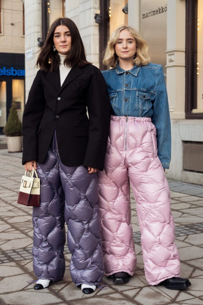 STOCKHOLM, SWEDEN - FEBRUARY 08: Linn Eklund and Fanny Ekstrand are seen wearing purple and pink Miu Miu quilted nylon pants outside Beckmans college of design show in Stockholm fashion week Autumn/Winter 2022 on February 08, 2022 in Stockholm, Sweden.